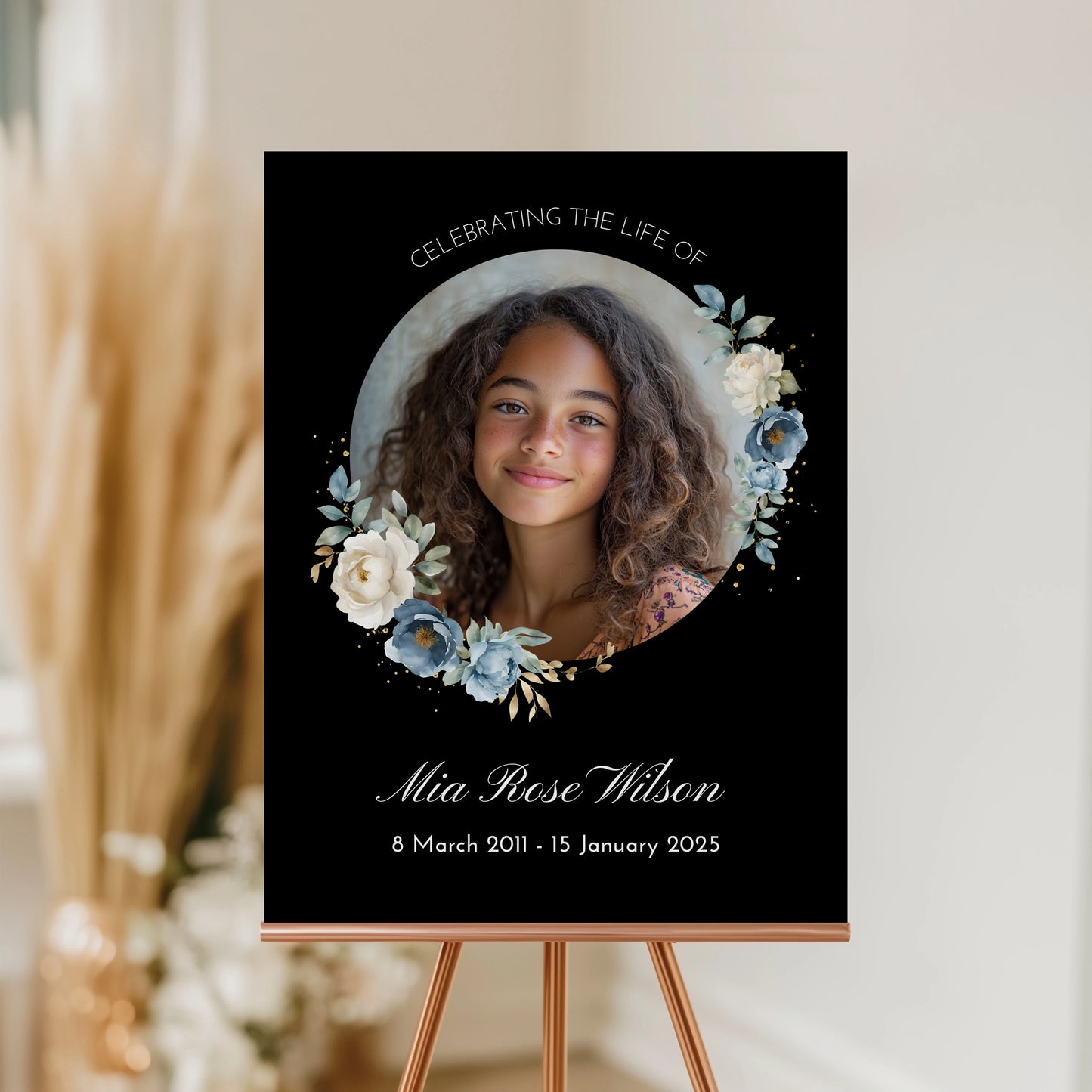 Personalized memorial welcome sign featuring a custom photo of a girl set in a circle, adorned with blue and white roses on a black background, honouring the life of Mia Rose Wilson with her date at the bottom.