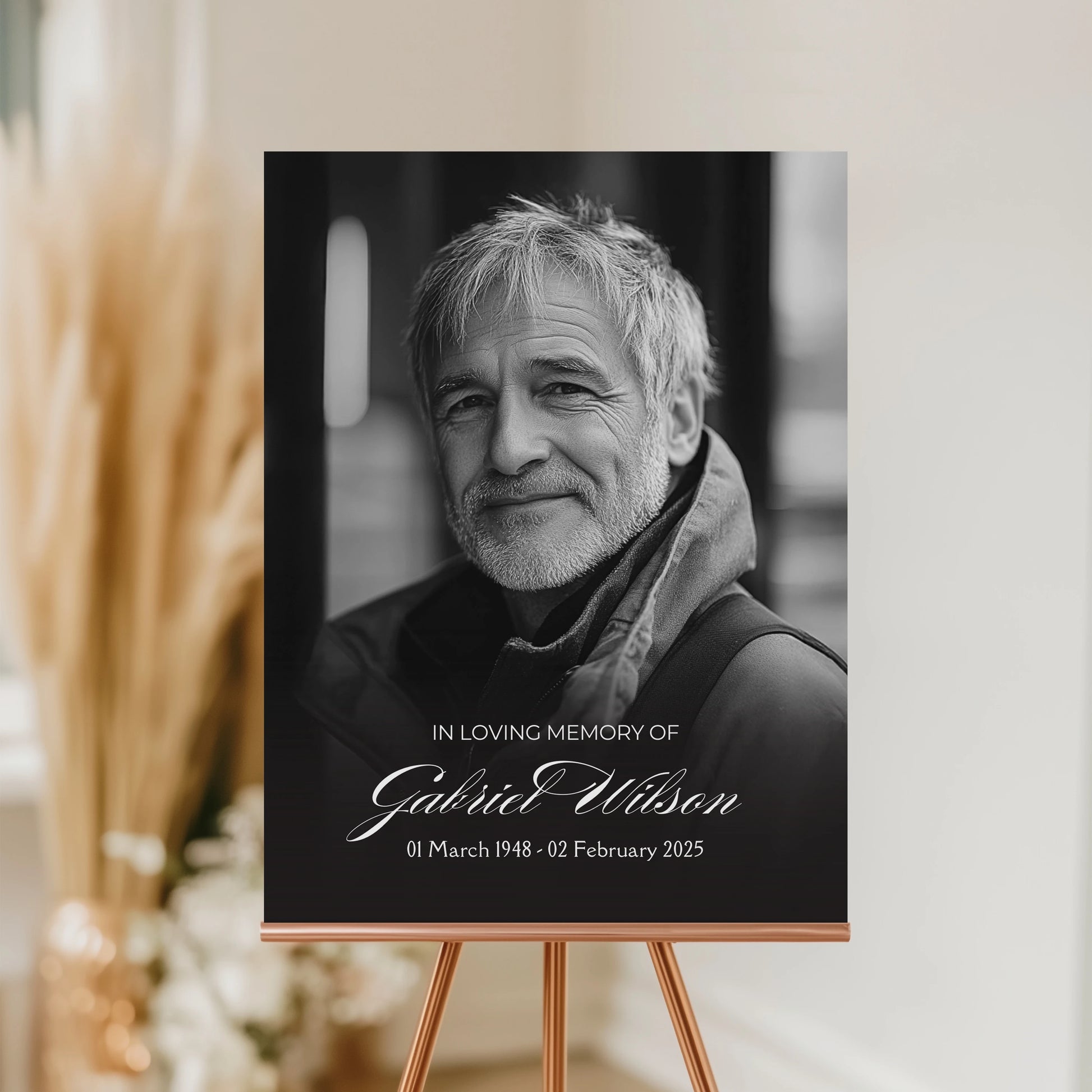 Minimalist funeral welcome sign featuring a smiling portrait of Gabriel Wilson with the inscription "In Loving Memory Gabriel Wilson" and his birth and passing dates.