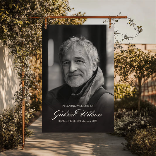 Minimalist funeral welcome sign featuring a smiling portrait of Gabriel Wilson with the inscription "In Loving Memory Gabriel Wilson" and his birth and passing dates.