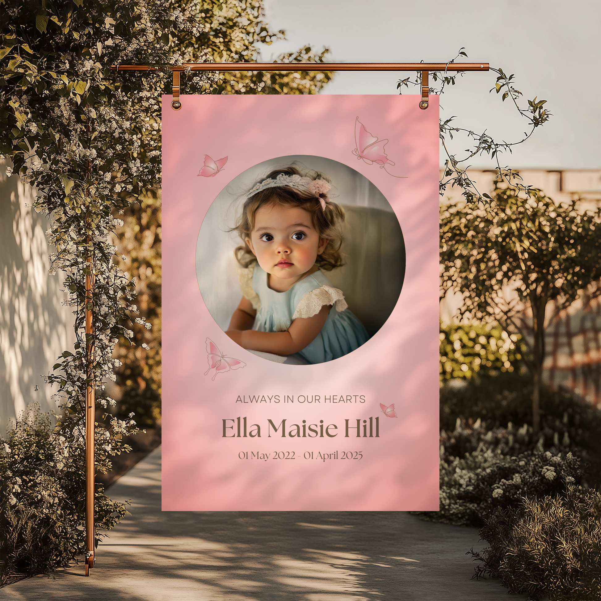 Memorial sign with a soft pink background, featuring a cherished photo, delicate butterfly accents, and personalised with the name "Ella Maisie Hill" and her dates. A beautiful tribute for remembrance and celebration of life.