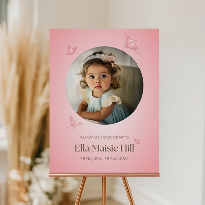 Memorial sign with a soft pink background, featuring a cherished photo, delicate butterfly accents, and personalised with the name "Ella Maisie Hill" and her dates. A beautiful tribute for remembrance and celebration of life.