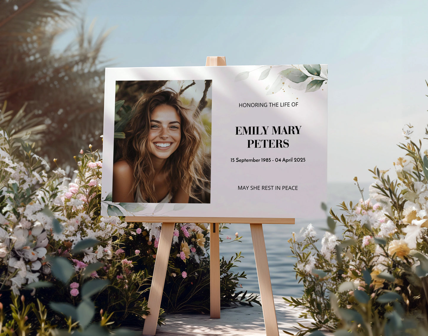 Memorial sign on a wooden easel at the beach, honouring a woman named Mary Louise Wilson. Features a soft eucalyptus design, her photo, name, and dates. Surrounded by white roses, candles, and flowers, creating a peaceful tribute.