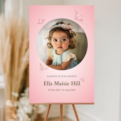 Memorial sign with a soft pink background, featuring a cherished photo, delicate butterfly accents, and personalised with the name "Ella Maisie Hill" and her dates. A beautiful tribute for remembrance and celebration of life.