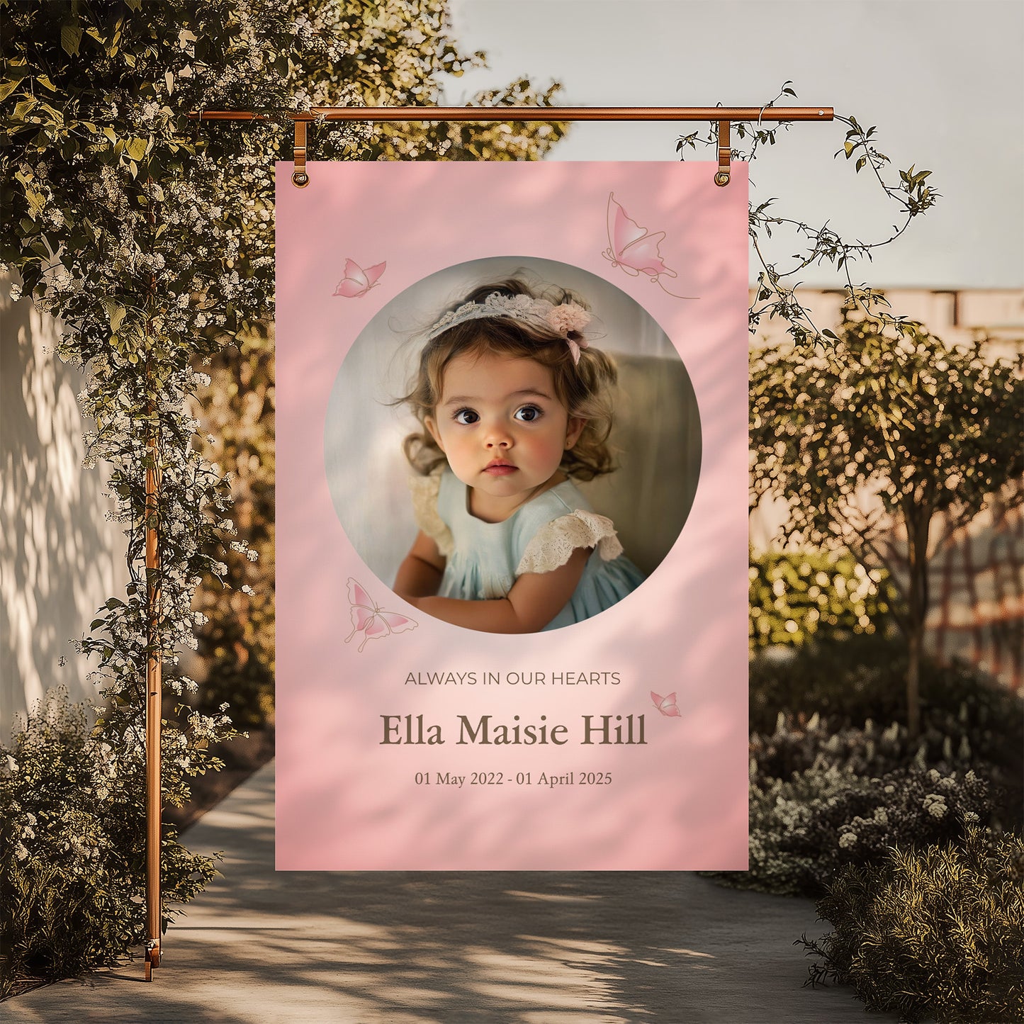 Memorial sign with a soft pink background, featuring a cherished photo, delicate butterfly accents, and personalised with the name "Ella Maisie Hill" and her dates. A beautiful tribute for remembrance and celebration of life.