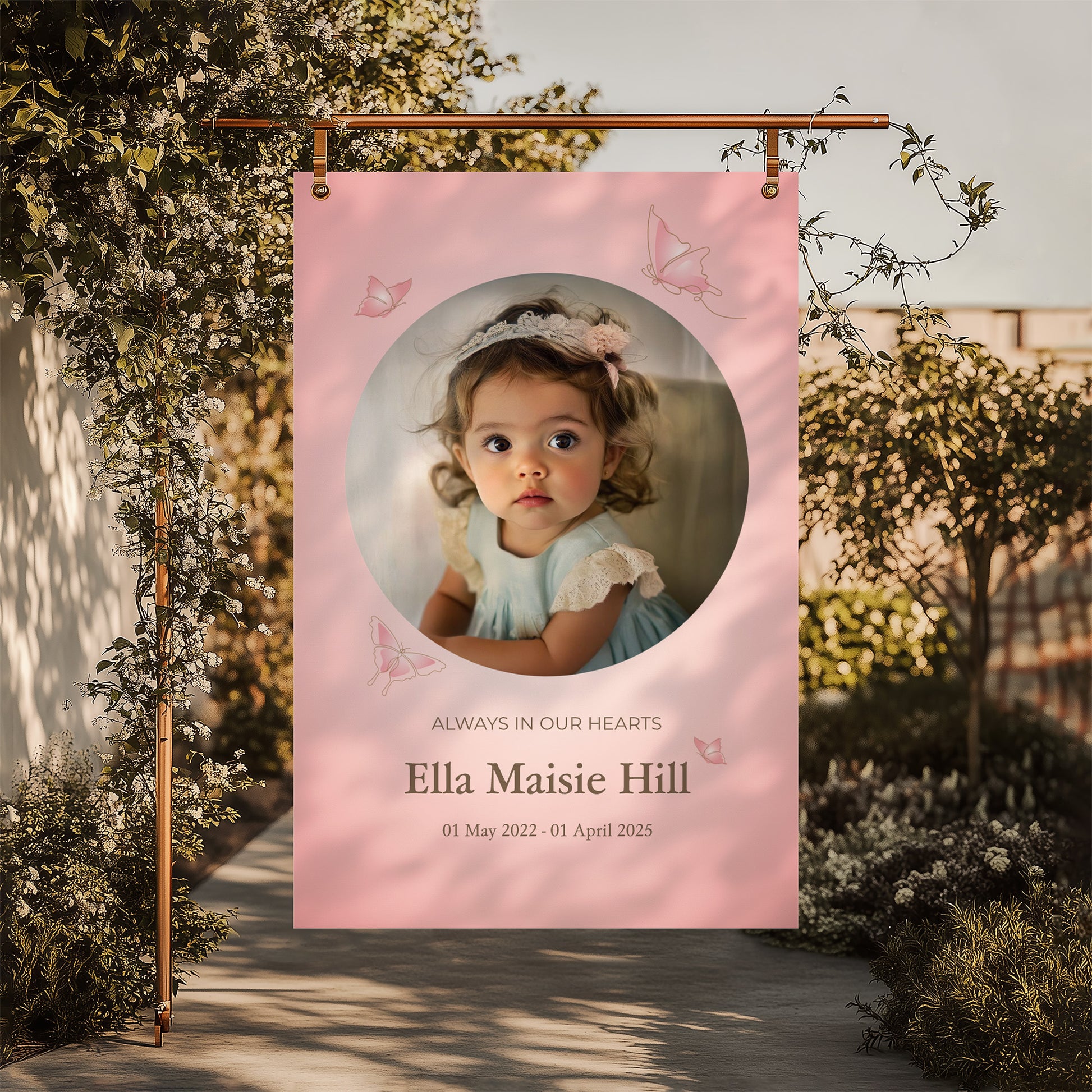 Memorial sign with a soft pink background, featuring a cherished photo, delicate butterfly accents, and personalised with the name "Ella Maisie Hill" and her dates. A beautiful tribute for remembrance and celebration of life.