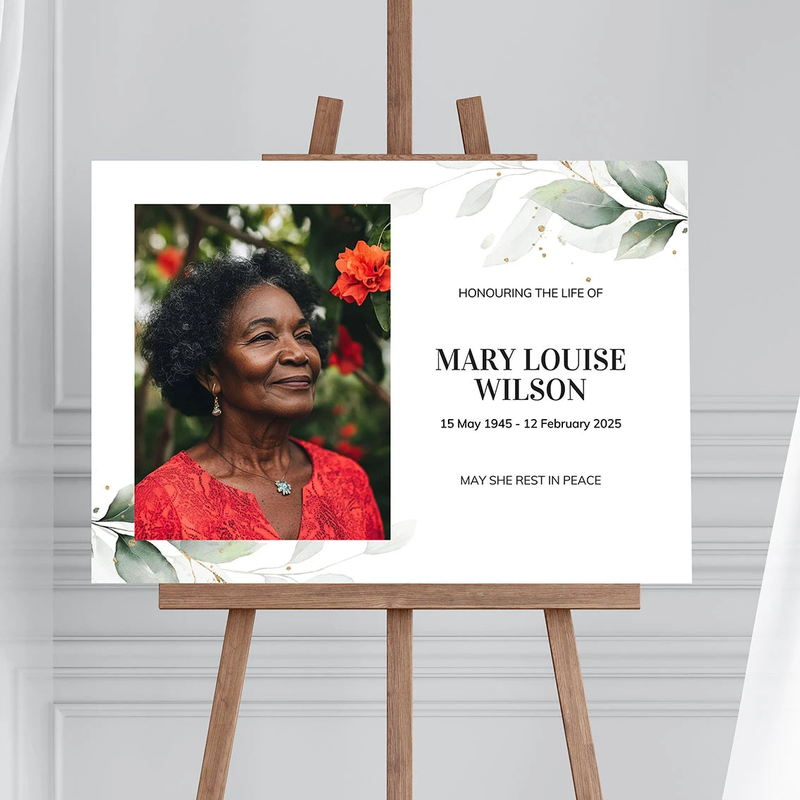 Memorial sign on a wooden easel at the beach, honouring a woman named Mary Louise Wilson. Features a soft eucalyptus design, her photo, name, and dates. Surrounded by white roses, candles, and flowers, creating a peaceful tribute.