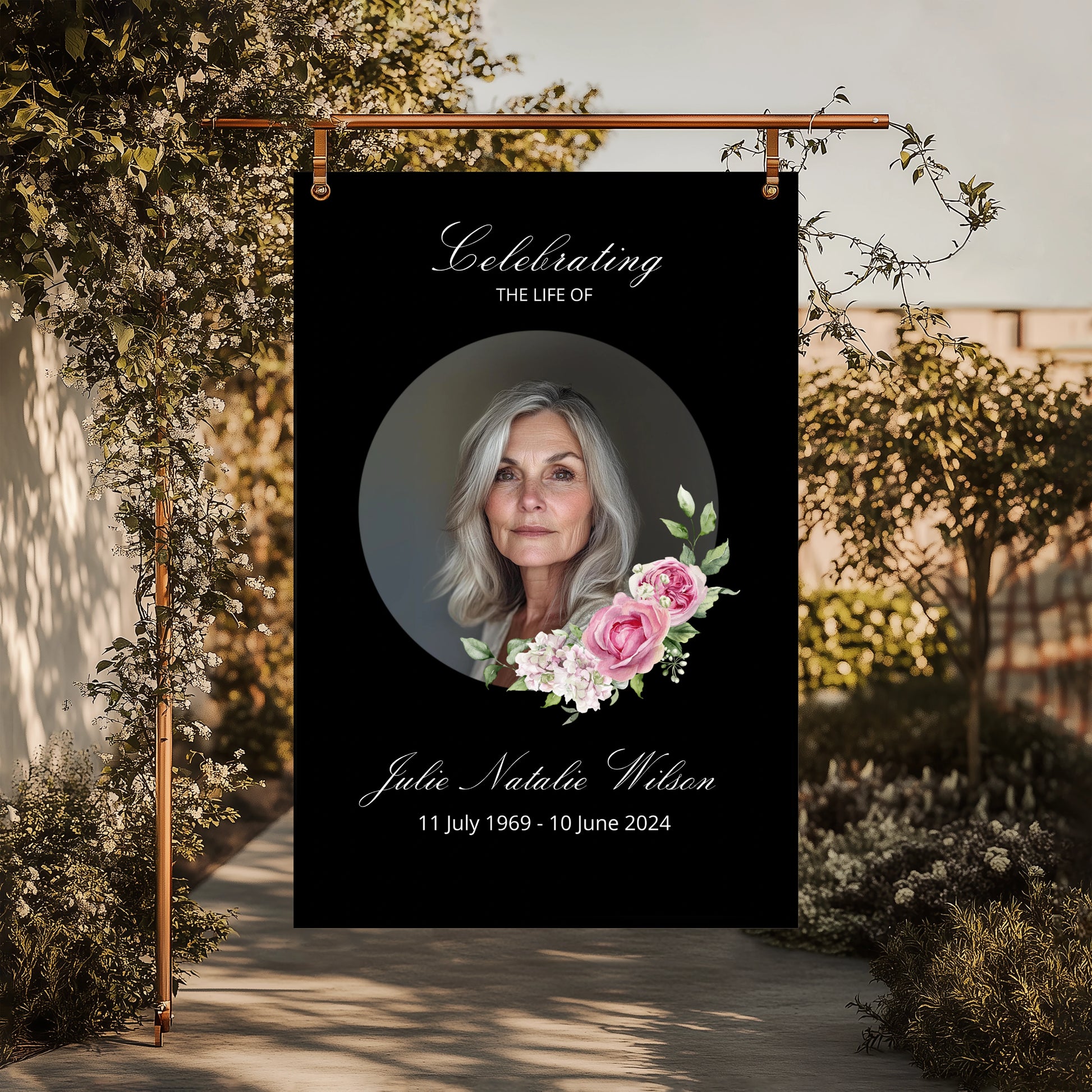 Memorial banner with a portrait of a woman and floral design, set against a garden background.