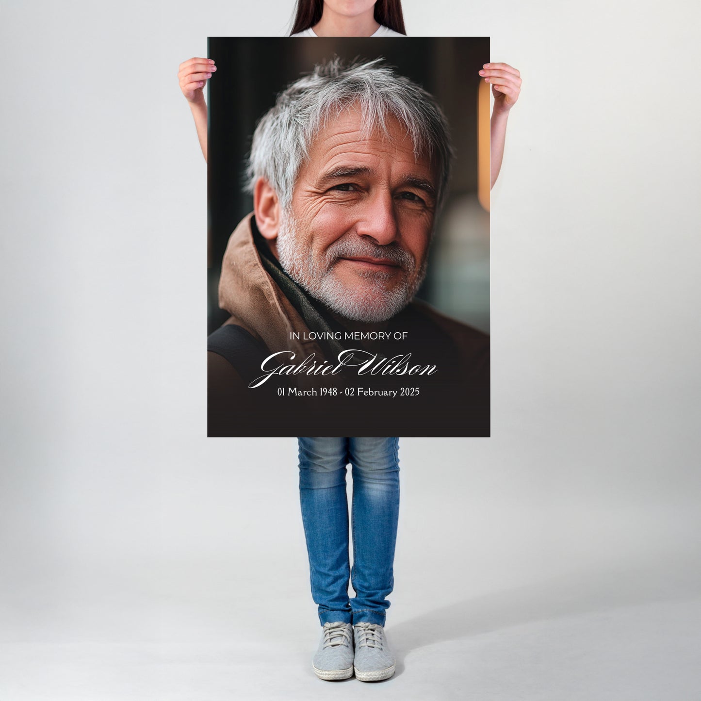 Person holding a poster with a portrait and text of a man, on a plain background