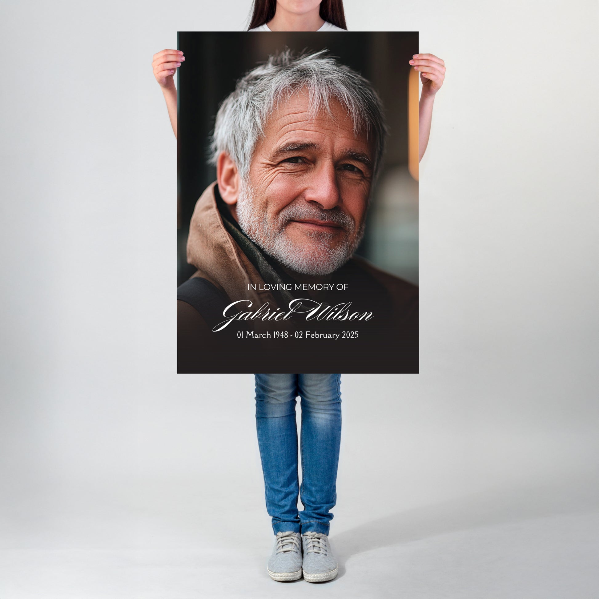 Person holding a poster with a portrait and text of a man, on a plain background